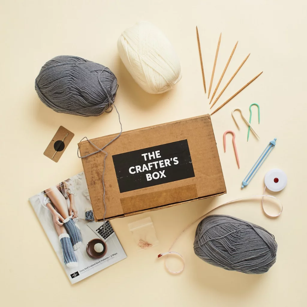 The Crafter's Box kit containing yarn and needlecraft tools.