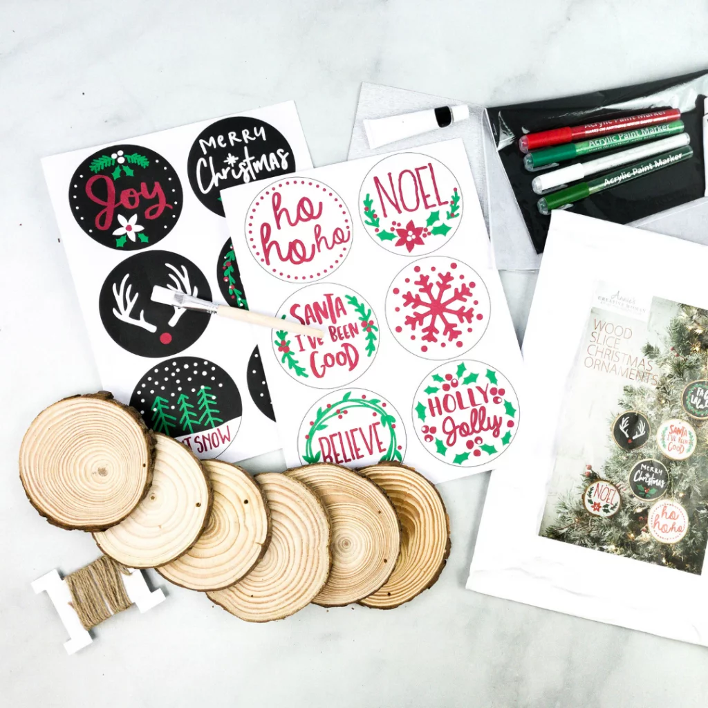 Wooden ornament discs with holiday designs and paint markers.